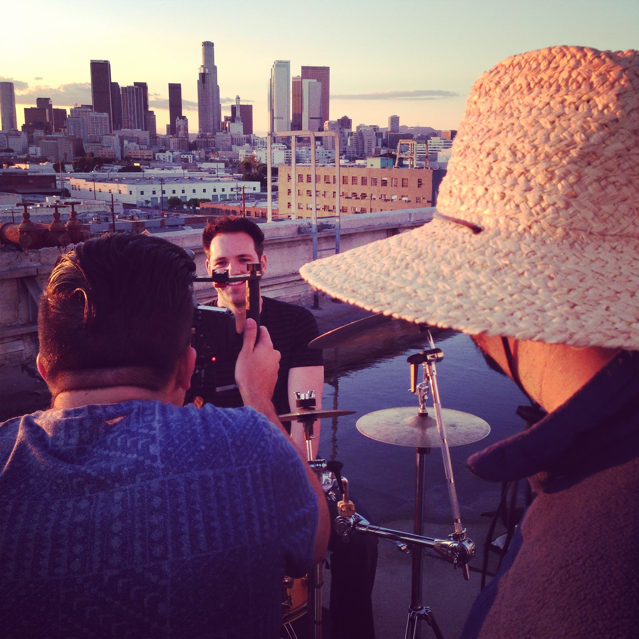 Camera operator framing musician with LA skyline